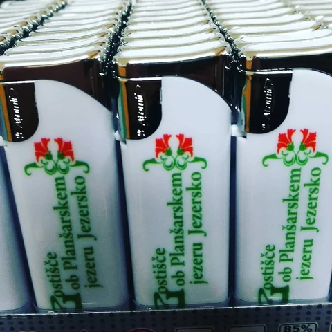 Beli vžigalniki z zelenim napisom in cvetličnim znakom